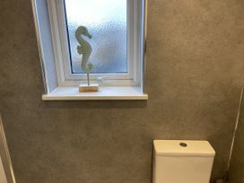 A bathroom with a toilet and a window at 22 Longstone Park Beadnell