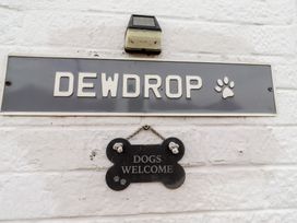 A nameplate and welcome sign mounted on a wall at 22 Longstone Park Beadnell