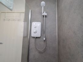A shower with a shower head and control unit at 22 Longstone Park Beadnell