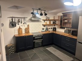 A kitchen with cabinets and appliances at Heol Madog in Porthmadog