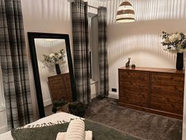 A bedroom with a bed and a dresser at Heol Madog in Porthmadog