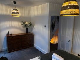 A bedroom with a chest of drawers and a flower arrangement at Heol Madog in Porthmadog
