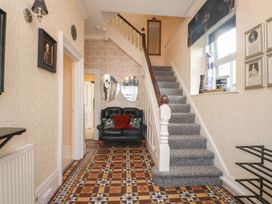 A hallway with a staircase and a sofa at The Causeway in Llandudno