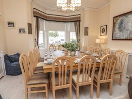 A dining room with a long table set for dinner at The Causeway in Llandudno
