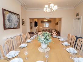 A dining room with a large table set for dinner at The Causeway in Llandudno