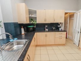 A kitchen with cabinets, sink, and microwave at The Causeway in Llandudno