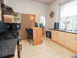A kitchen with a bar counter and stools at The Causeway in Llandudno