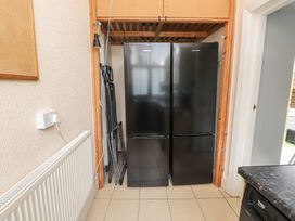 A kitchen with a fridge and freezer alongside a radiator at The Causeway in Llandudno