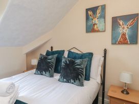 A bedroom with a bed and wall art at The Causeway in Llandudno