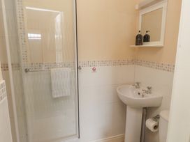 A bathroom with a shower, wash basin, and toilet at The Causeway in Llandudno