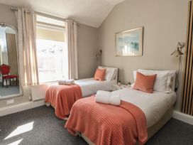 A bedroom with two beds and a mirror at The Causeway in Llandudno