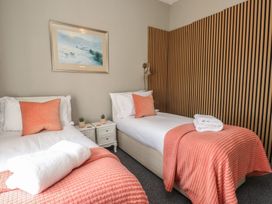 A bedroom with two beds, nightstands, and wall art at The Causeway in Llandudno