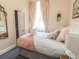 A bedroom with a bed and mirror at The Causeway in Llandudno