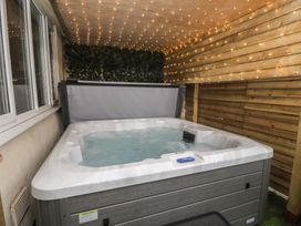 A hot tub with fairy lights and wooden walls at The Causeway in Llandudno