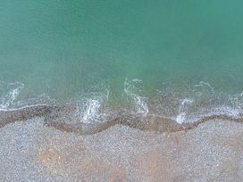 A shoreline with pebbles and water at The Causeway in Llandudno