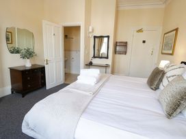 A bedroom with a bed and mirror at The Causeway in Llandudno
