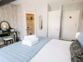 A bedroom with a bed and a vanity table at The Causeway in Llandudno