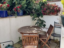A garden with a table and chairs surrounded by flower pots at Quarrier's Rest in Swanage