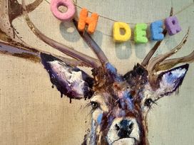 A painted deer head with colorful letters spelling oh deer hanging above its antlers at Oh Deer in Ashbourne