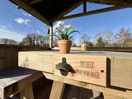 An outdoor seating area with a table and flower pot at Oh Deer in Ashbourne