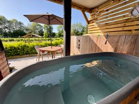 An outdoor area with a hot tub and a table with chairs at Oh Deer Ashbourne