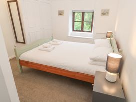 A bedroom with a bed and nightstand at Sunnyvale Cottage in Rosudgeon