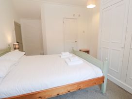 A bedroom with a bed and wardrobe at Sunnyvale Cottage in Rosudgeon