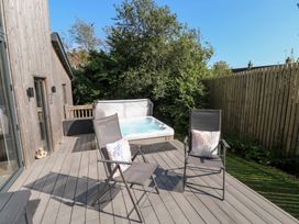 An outdoor area with a hot tub and chairs at Cornerstones Brython in Tenby