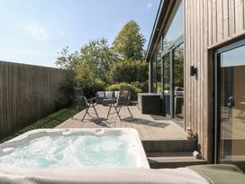 An outdoor area with a hot tub and seating at Cornerstones Brython in Tenby