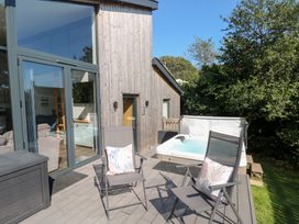 An outdoor area with chairs and a hot tub at Cornerstones Brython in Tenby