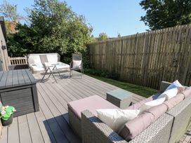 A garden with a hot tub and seating area at Cornerstones Brython in Tenby