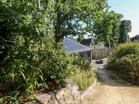 A garden with a pathway and solar panel house at Cornerstones Brython in Tenby
