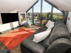 A living room with a sofa and television at 11 Brython Place Tenby
