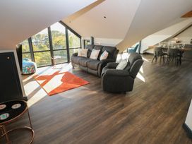 A living room with a sofa and dining area at 11 Brython Place Tenby
