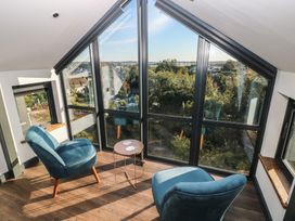 A living room with two chairs and a table at 11 Brython Place in Tenby