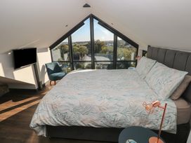 A bedroom with a bed and window at 11 Brython Place in Tenby