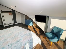 A bedroom with a bed and a television at 11 Brython Place Tenby