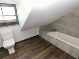 A bathroom with a toilet and bathtub at 11 Brython Place in Tenby