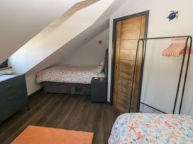 A bedroom with two beds and a clothes rack at 11 Brython Place Tenby