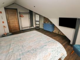 A bedroom with a bed and television at 11 Brython Place in Tenby