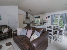 A living room with a sofa and dining area at Seacroft in Stepaside near Kilgetty