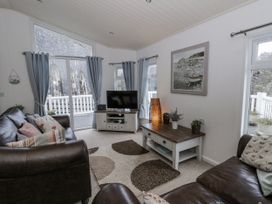 A living room with a television and sofa at Seacroft Stepaside near Kilgetty