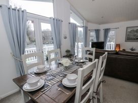 A dining room with a table set for meals at Seacroft near Kilgetty