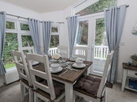 A dining room with a table and chairs at Seacroft in Stepaside near Kilgetty