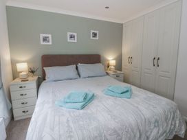 A bedroom with a bed and bedside tables at Seacroft Stepaside near Kilgetty