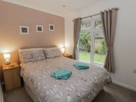 A bedroom with a bed and window at Seacroft in Stepaside near Kilgetty