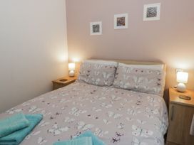 A bedroom with a bed and bedside tables at Seacroft in Stepaside near Kilgetty