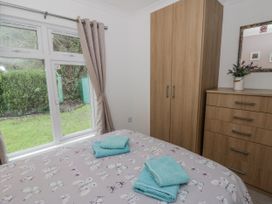 A bedroom with two towels on the bed at Seacroft Stepaside near Kilgetty