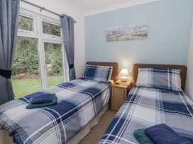 A bedroom with two single beds and a nightstand at Seacroft near Kilgetty