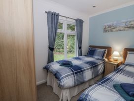 A bedroom with two beds and window at Seacroft in Stepaside near Kilgetty